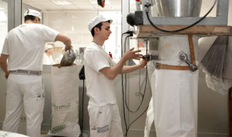 Ein Mann füllt Säcke mithilfe einer Maschine mit Getreide auf.