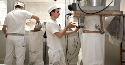 Ein Mann füllt Säcke mithilfe einer Maschine mit Getreide auf.