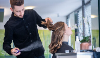 Ein Mann frisiert einer Frau die Haare.