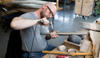 Ein Mann bearbeitet eine Zinnpfeife.