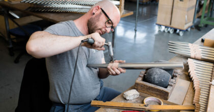 Ein Mann bearbeitet eine Zinnpfeife.