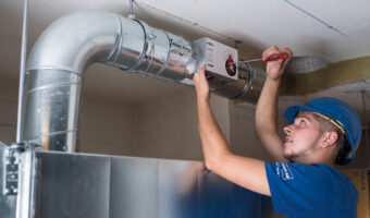 Ein Mann baut ein Lüftungsrohrsystem zusammen.