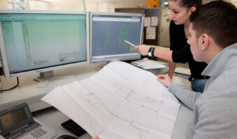 Ein Mann und eine Frau schauen und besprechen Baupläne.