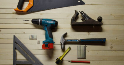 Diverse Werkzeuge liegen schön angeordnet auf Holzbrettern.