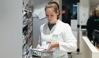 Eine Frau überprüft Medikamente in der Apotheke.