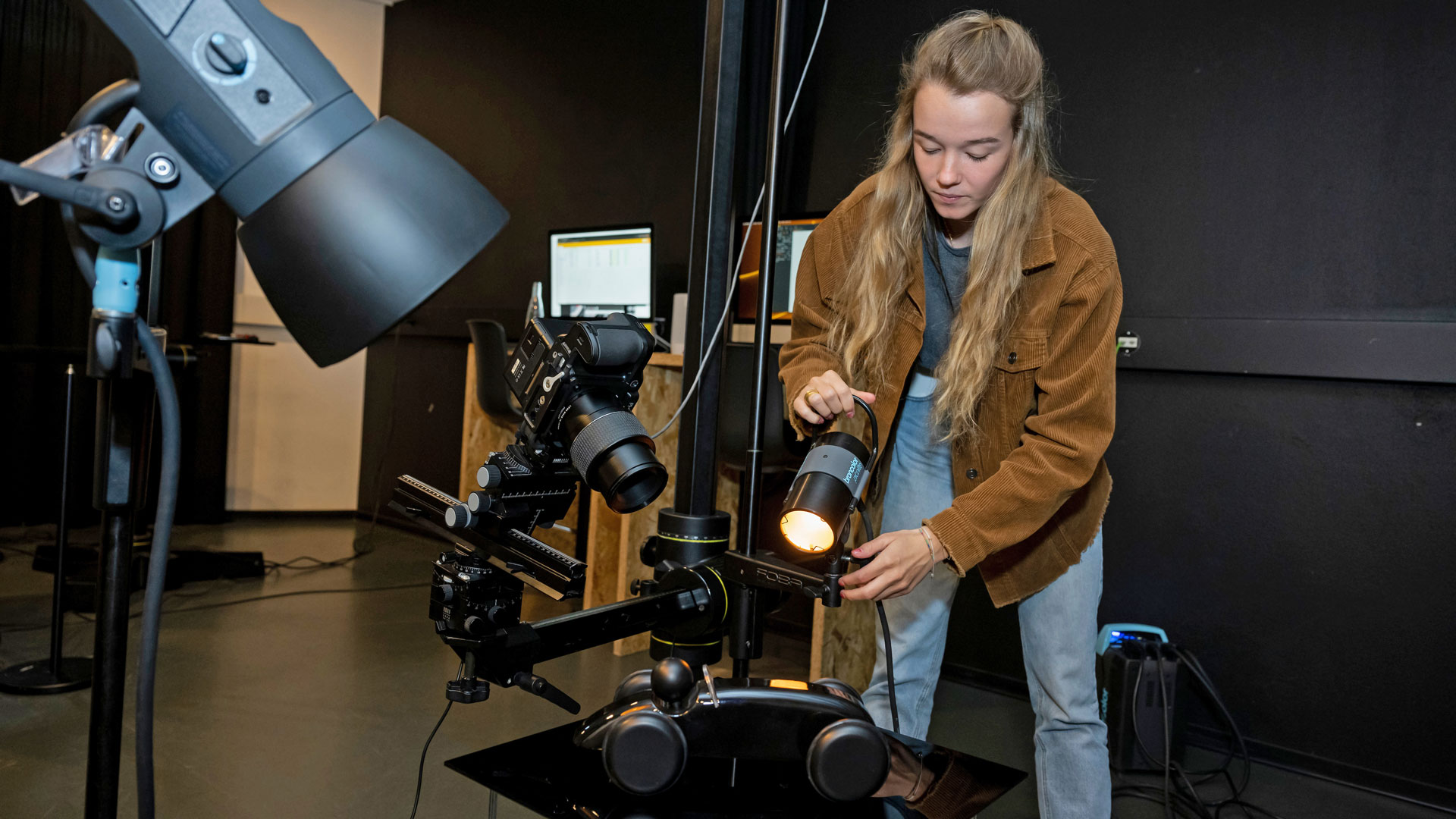 Eine Frau richtet bei einer vorbereiteten Aufnahme das Licht perfekt aus..