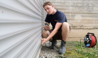 Ein Mann kniet am Boden und prüft eine montierte Store.
