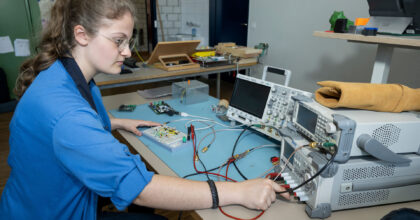 Eine Frau sitzt an einem Tisch und macht Messungen.