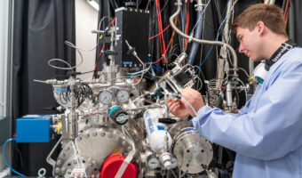 Ein junger Mann hantiert an einer Apparatur mit vielen Schläuchen und Anzeigen.