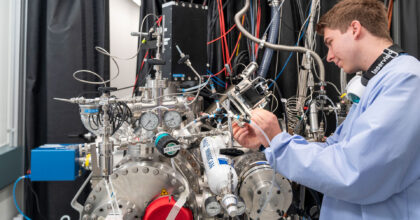 Ein junger Mann hantiert an einer Apparatur mit vielen Schläuchen und Anzeigen.