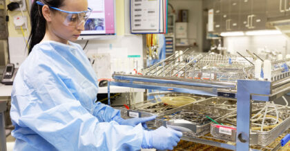 Eine Frau in Schutzkleidung prüft bereitgestellte Medizinprodukte.